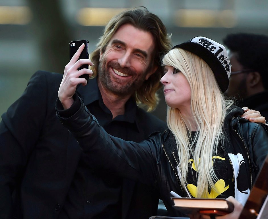 Sharlto Copley poses for a photograph with a fan as he arrives for the gala screening of the film 