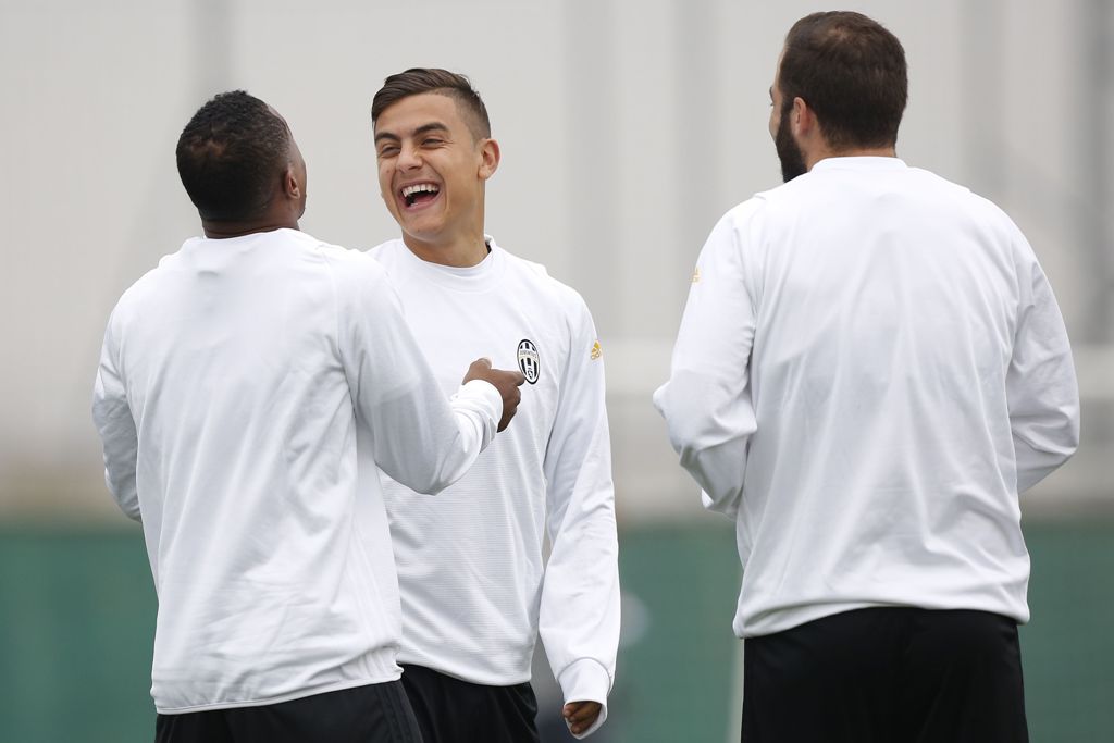 Juventus' forward Paulo Dybala from Argentina (2nd L), defender Patrice Evra from France (L) and forward Gonzalo Higuain from Argentina take part in a training session on the eve of a UEFA Champions League football match against Olympique Lyonnais on Octo