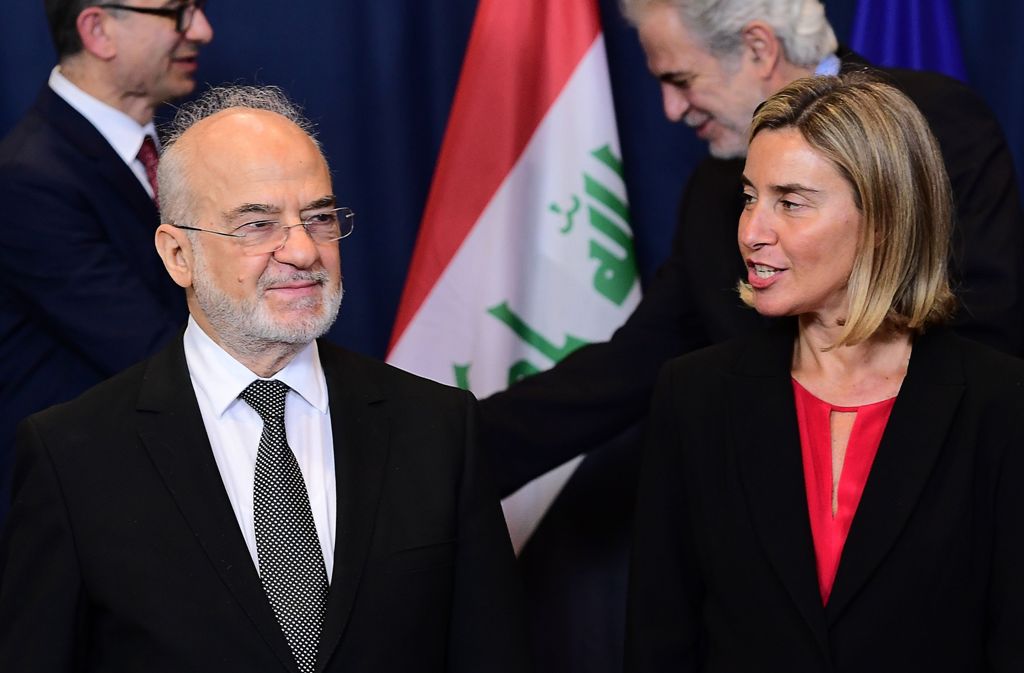 Iraqi Foreign Minister Ibrahim al-Jaafari (L) listens to EU foreign affairs chief Federica Mogherini after posing for a family photo at the end of an EU-Iraq Cooperation Council, at the European Council in Brussels on October 18, 2016. / AFP / EMMANUEL DU