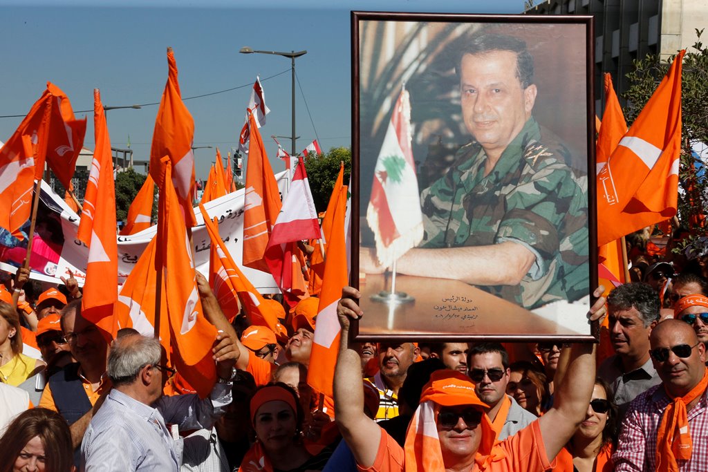 Supporters of the Free Patriotic Movement (FPM) carry flags and a picture of FPM founder and politician Michel Aoun during a rally to show support for Aoun and calling to elect a president, near the presidential palace in Baabda, near Beirut, Lebanon Octo