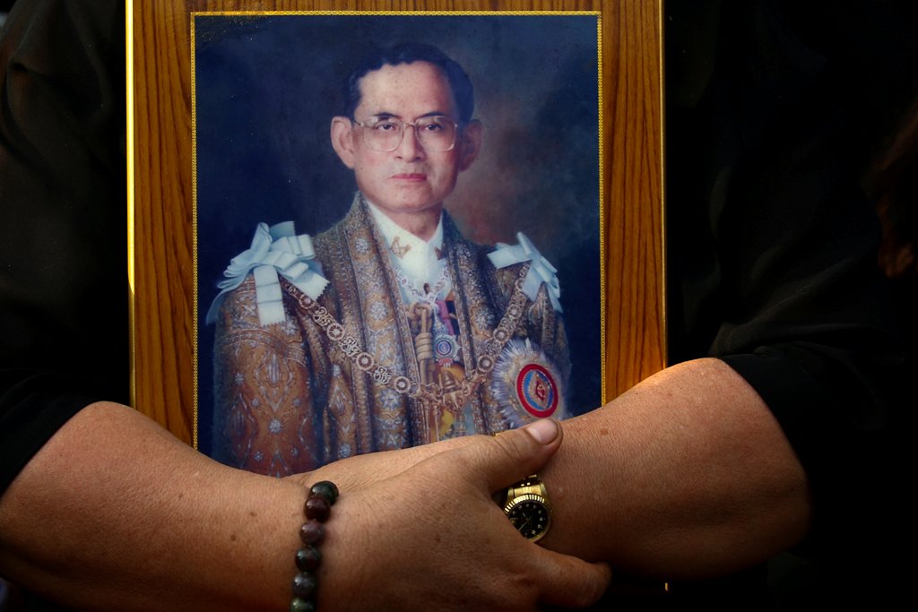 A mourner holds a portrait of Thailand's late King Bhumibol Adulyadej in Bangkok, Thailand, October 14, 2016. REUTERS/Athit Perawongmetha/File Photo.