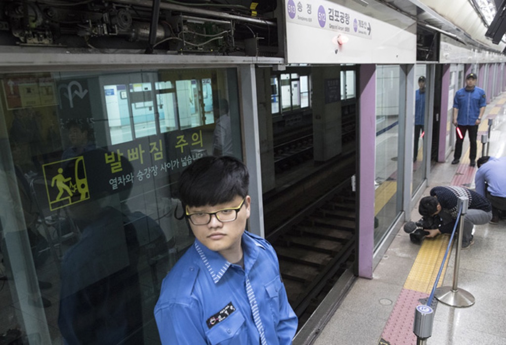 Security guards watch over the site where a man, 36, died after being caught in the gap between a train and a platform safety screen door at Gimpo International Airport Station on Wednesday morning. / Yonhap
