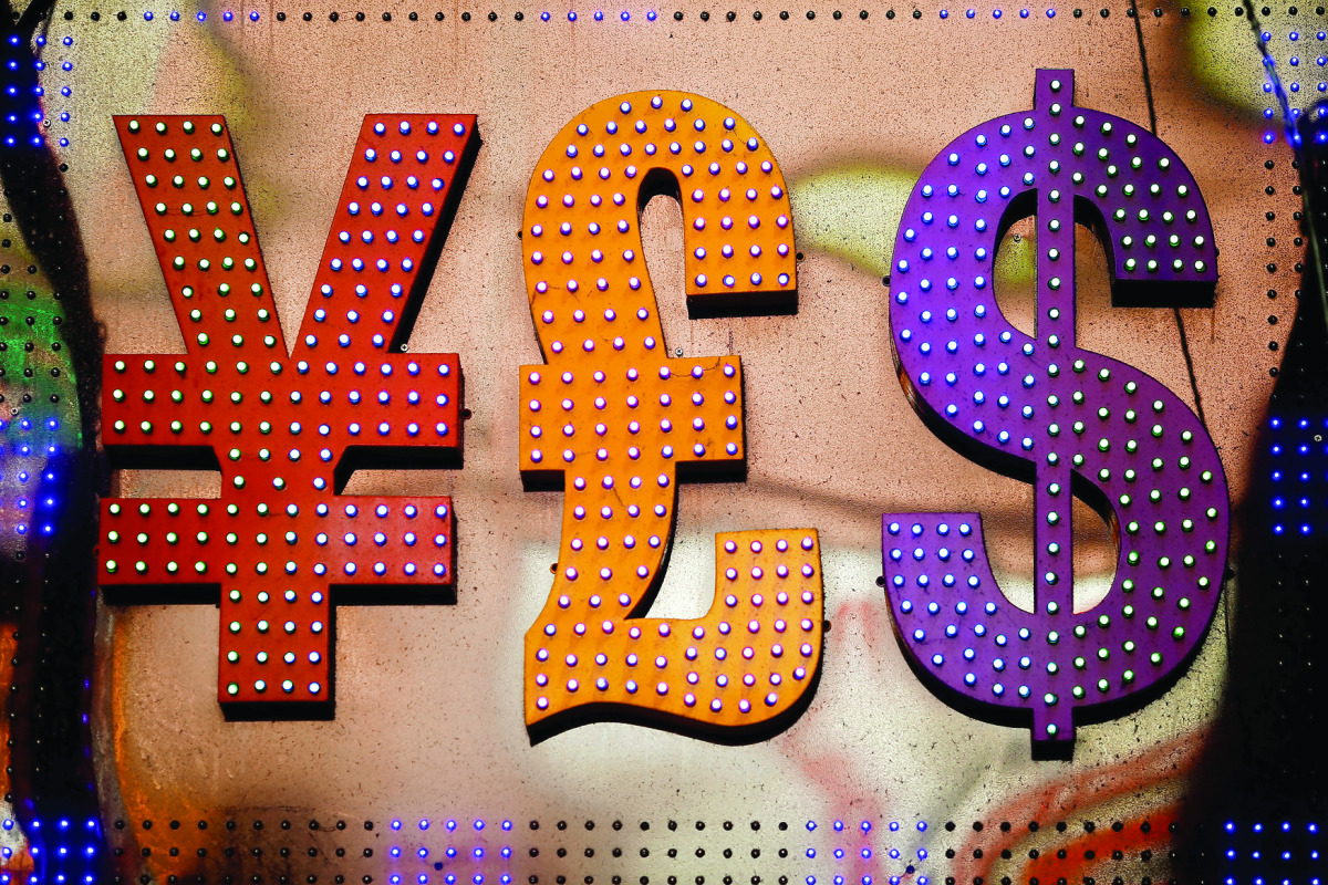 The dollar sign is seen alongside the signs for other currencies above a currency exchange shop at Mongkok shopping district in Hong Kong, China.