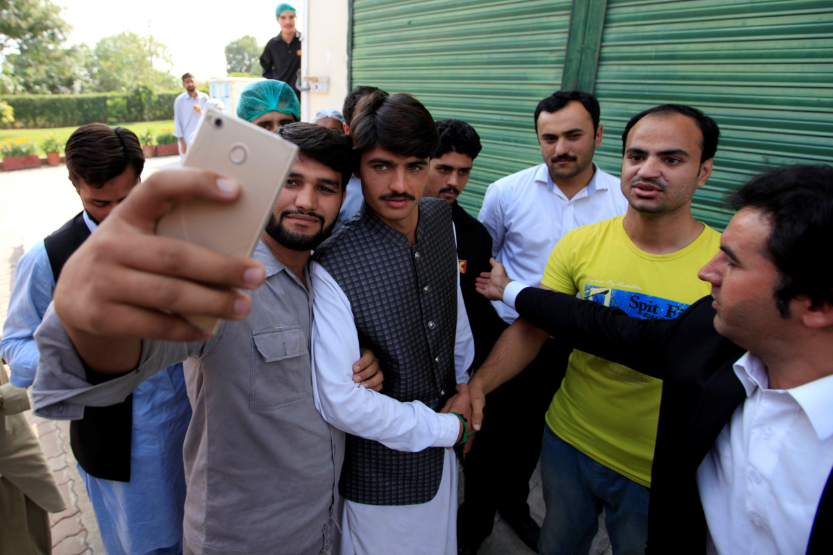 Arshad Khan (C), formerly a chai wala (tea seller) by profession, posses for a selfie with fans after doing a television interview in Islamabad, Pakistan October 20, 2016. (Reuters/Faisal Mahmood)