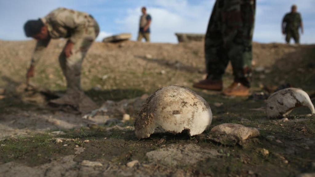 Kurdish militiamen on Sunday show what they say is a mass grave of about 50 Yazidis killed by Islamic State fighters near Sinjar, Iraq. (John Moore / Getty Images)