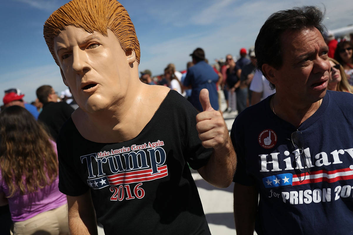 People wait for the arrival of Republican presidential candidate Donald Trump for his campaign rally at the Million Air Orlando, which is at Orlando Sanford International Airport on October 25, 2016 in Sanford, Florida. Trump continues to campaign against