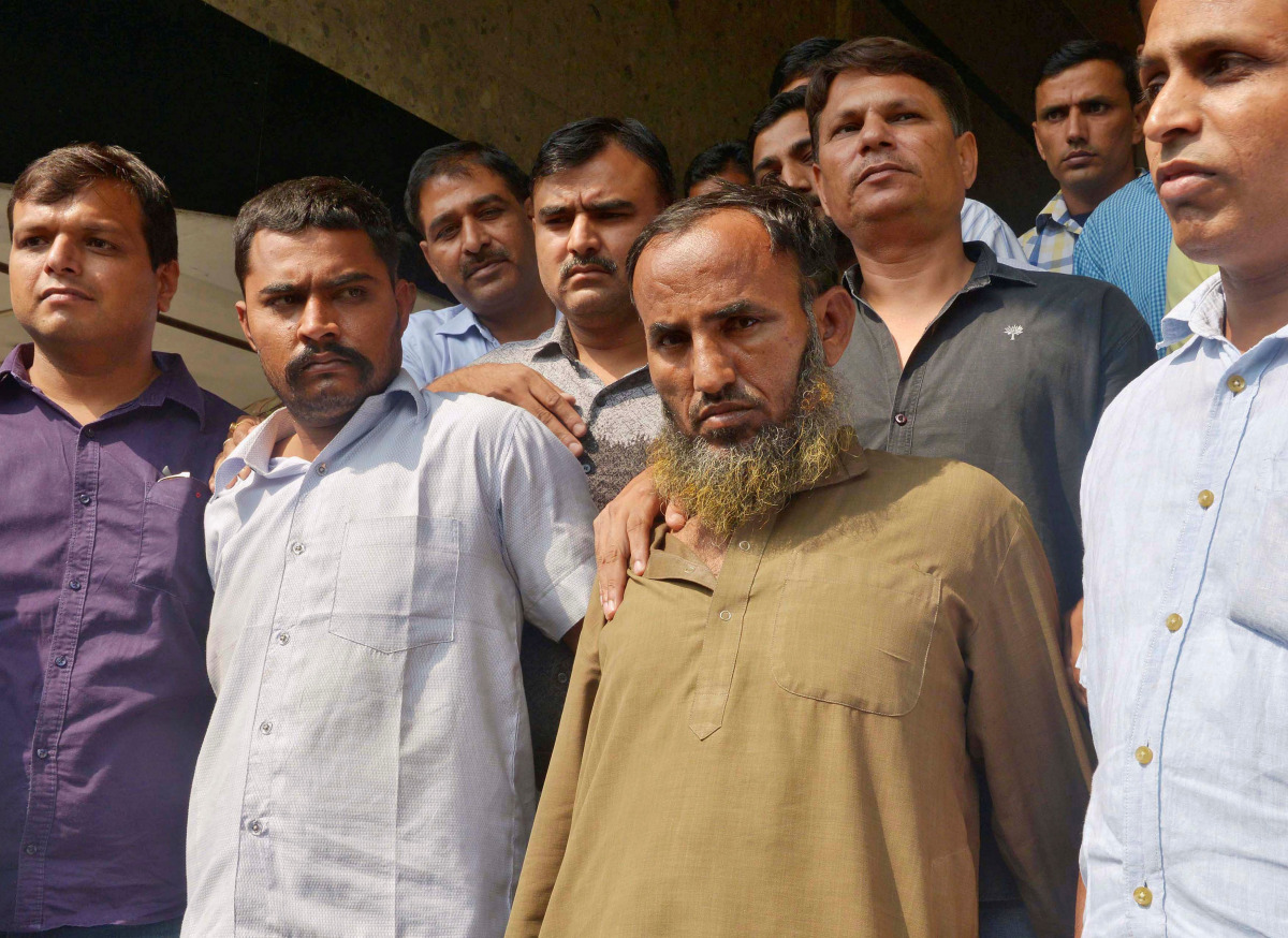 Plain-clothes policemen present two Indian men (bottom 2nd R and 2nd L), who they said are accused of spying for Pakistan, before the media inside the police headquarters in New Delhi, India, October 27, 2016. REUTERS