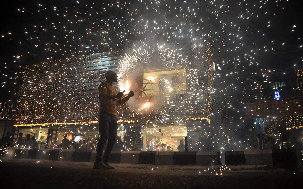 An Indian worker bursts firecrackers during a fireworks display at a local marketplace on the eve of Diwali festival in Jammu. AFP / STRINGER