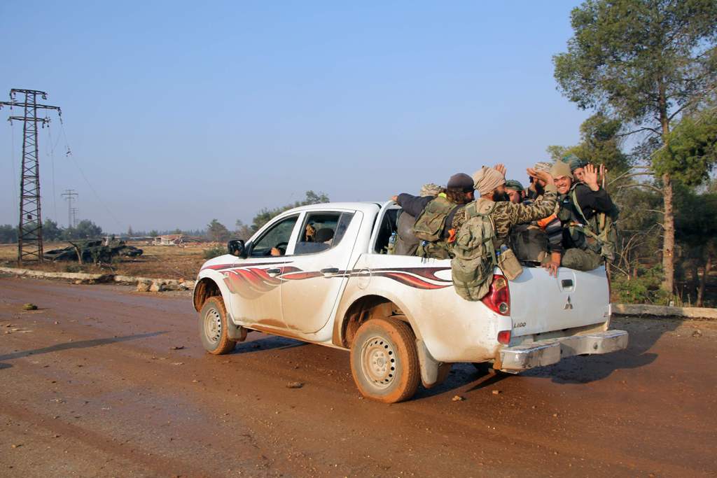 Rebel fighters from the Jaish al-Fatah (or Army of Conquest) brigades drive a pick-up on October 29, 2016 in the neighbourhood of Dahiyet al-Assad, southwest of Aleppo, after they retook control of the area.  AFP / Omar haj kadour