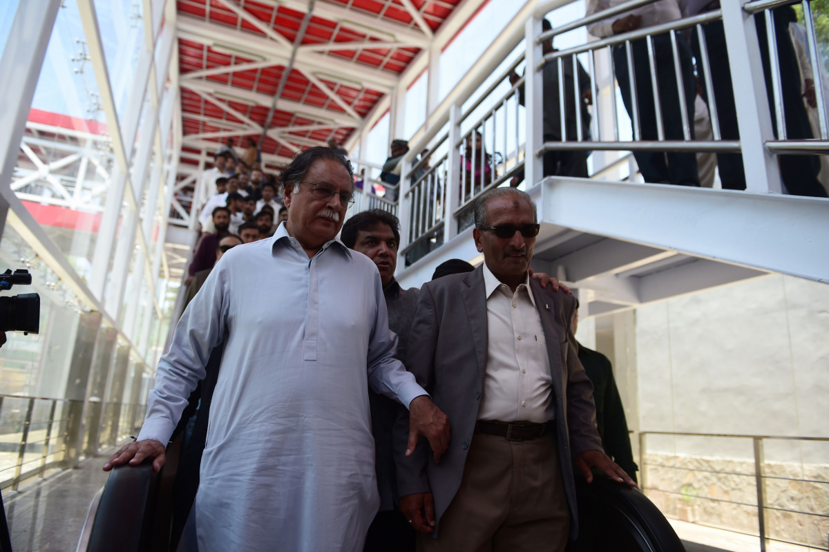 In this photograph taken on June 1, 2015, Pakistan Information Minister Pervez Rasheed (L) steps down from the escalator during a visit to Metro Bus station in Islamabad. Pakistan prime minister Nawaz Sharif on October 29, 2016, removed a key minister of 