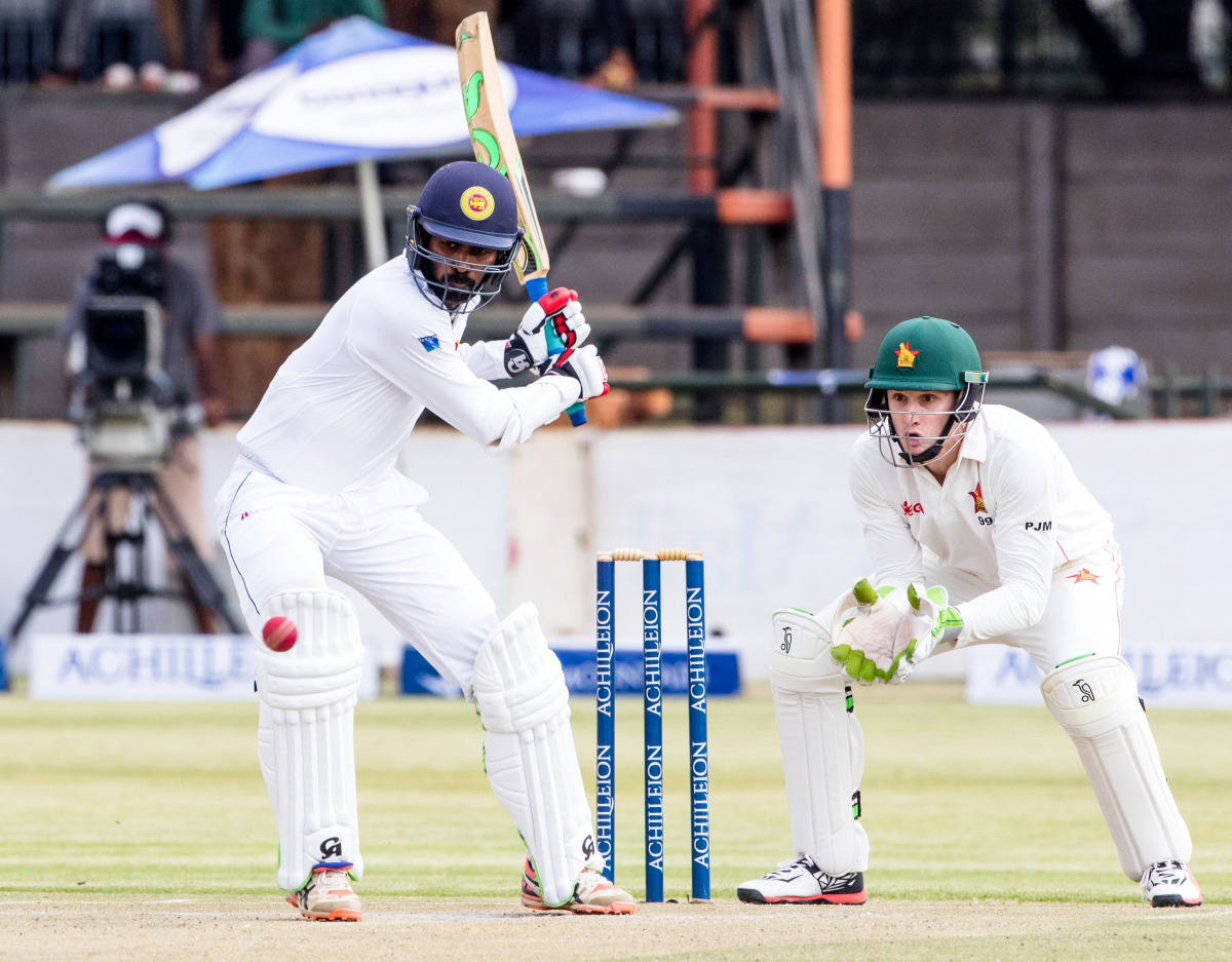Sri Lanka batsman Upul Tharanga is in action as Peter Moor looks on during the second day's play in the first Test match between Sri Lanka and hosts Zimbabwe at the Harare Sports Club, on October 30, 2016. (AFP / Jekesai Njikizana)