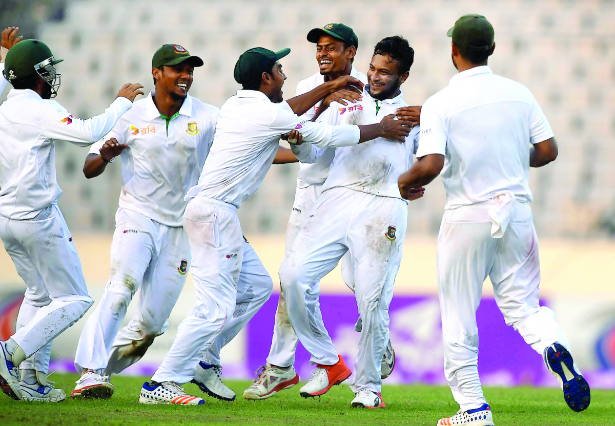 Bangladesh's Shakib Al Hasan (2R) celebrates with teammates after taking the wicket of England's Zafar Ansari during the third day of the second Test cricket match Bangladesh and England at the Sher-e-Bangla National Cricket Stadium in Dhaka on October 30