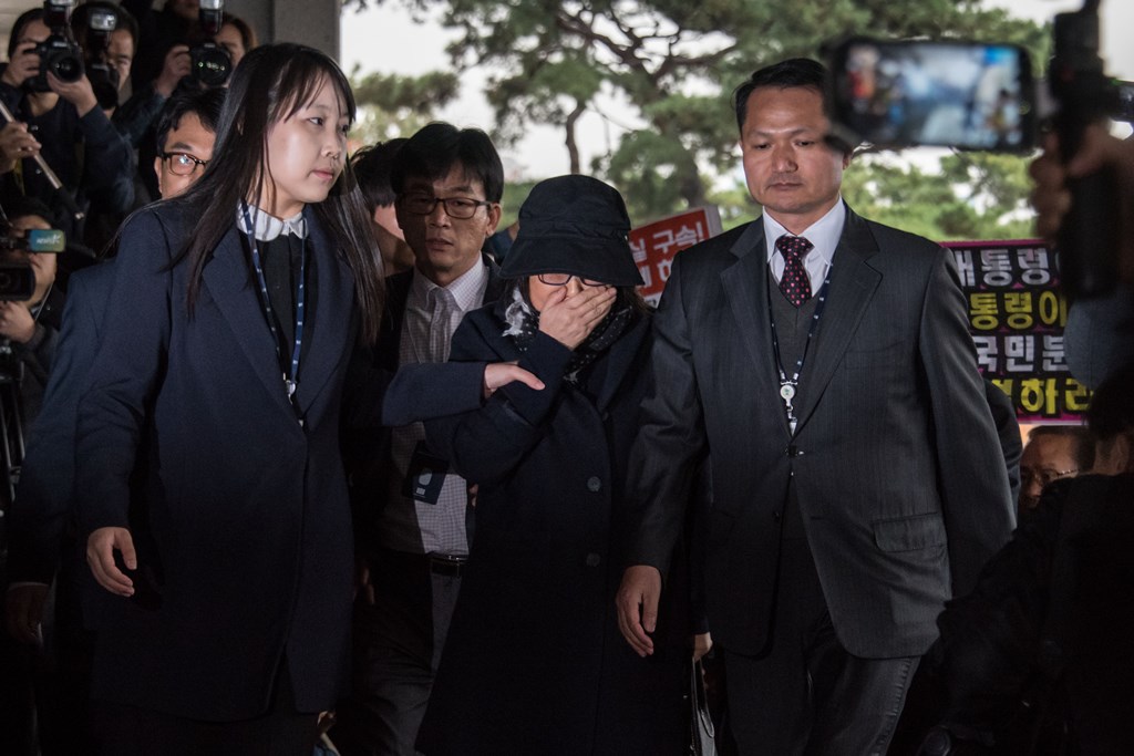 Choi Soon-Sil (C) is escorted as she arrives at the Seoul Central District Prosecutor's Office in Seoul on October 31, 2016. AFP / Ed Jones