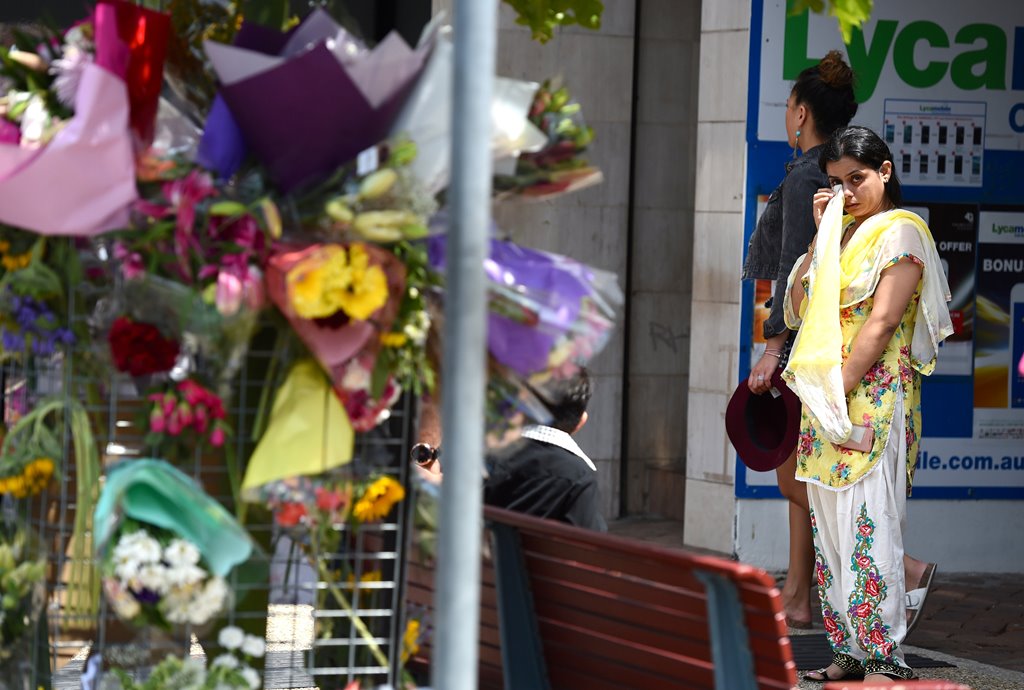 A woman reacts as she looks at a floral tribute for a bus driver that was murdered last Friday in Brisbane, Australia, October 30, 2016. AAP/Dan Peled/REUTERS 
