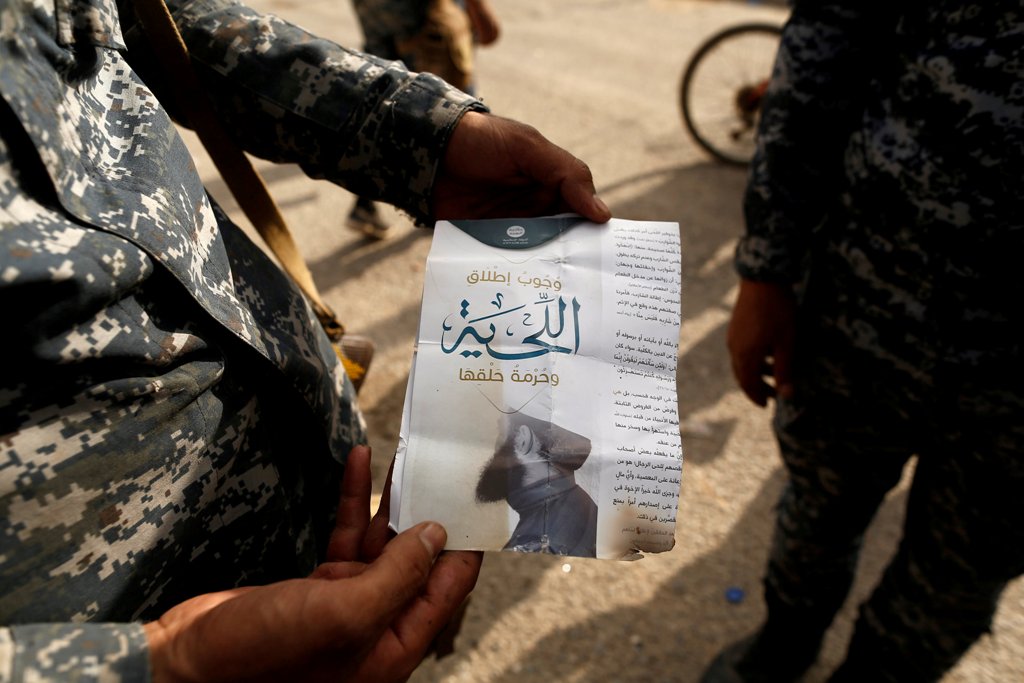 An Iraqi soldier shows a pamphlet which reads 