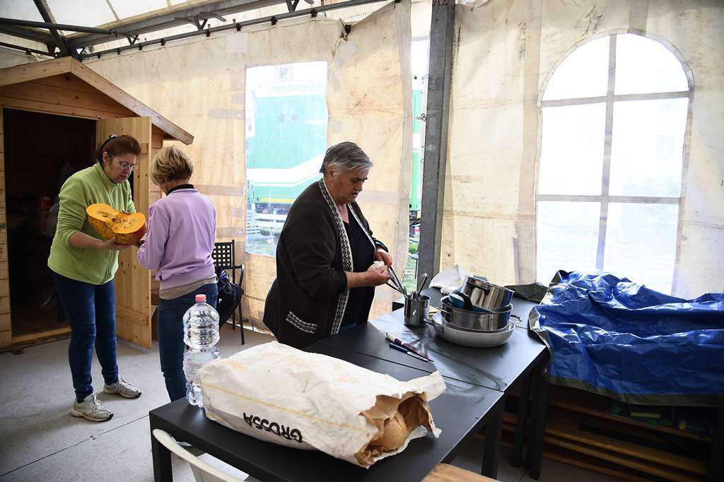 Residents cook under a tent in San Pellegrino near Norcia, on November 2, 2016 three days after a 6.5 magnitude earthquake hit central Italy. AFP / FILIPPO MONTEFORTE