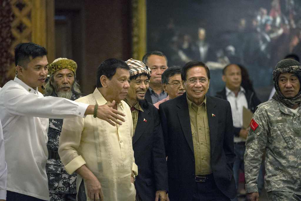 Philippine President Rodrigo Duterte (3rd L) walks beside Moro National Liberation Front founder Nur Misuari (C) at the Malacanang Palace on November 3, 2016. / AFP / NOEL CELIS
