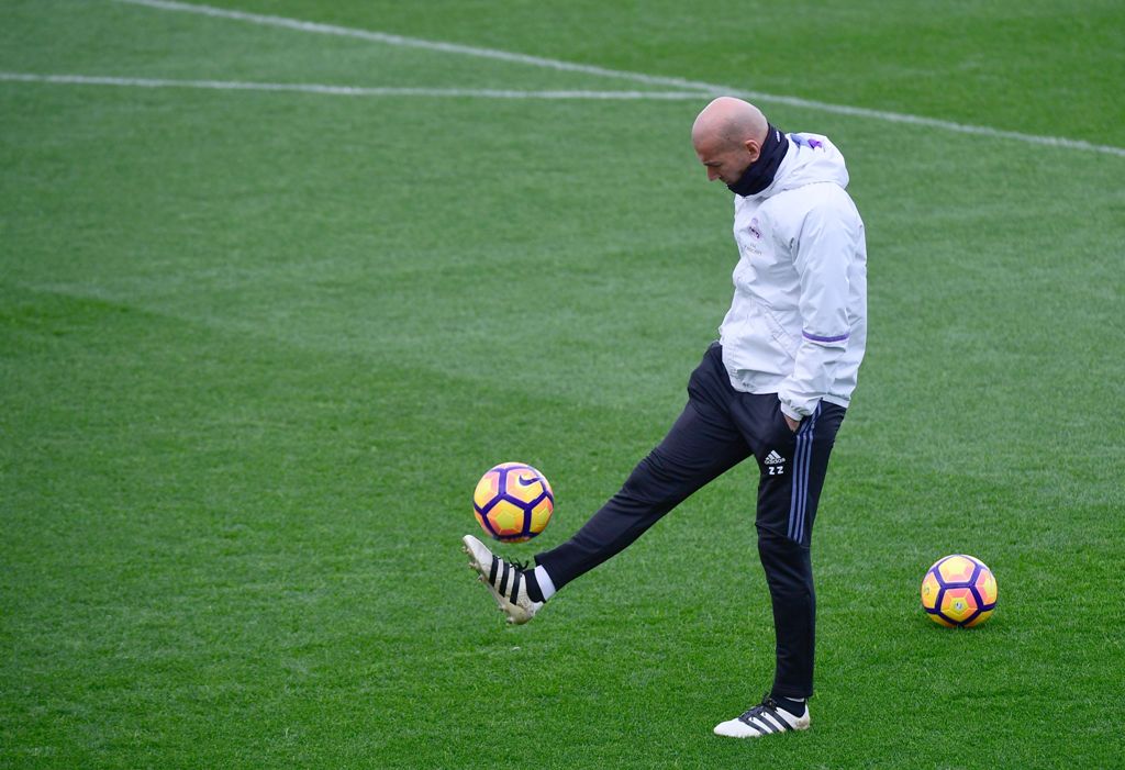 Real Madrid's French coach Zinedine Zidane plays with a ball during a training session at Valdebebas Sport City in Madrid on November 5, 2016 on the eve of their Spanish Liga football match against Leganes. / AFP / PIERRE-PHILIPPE MARCOU
