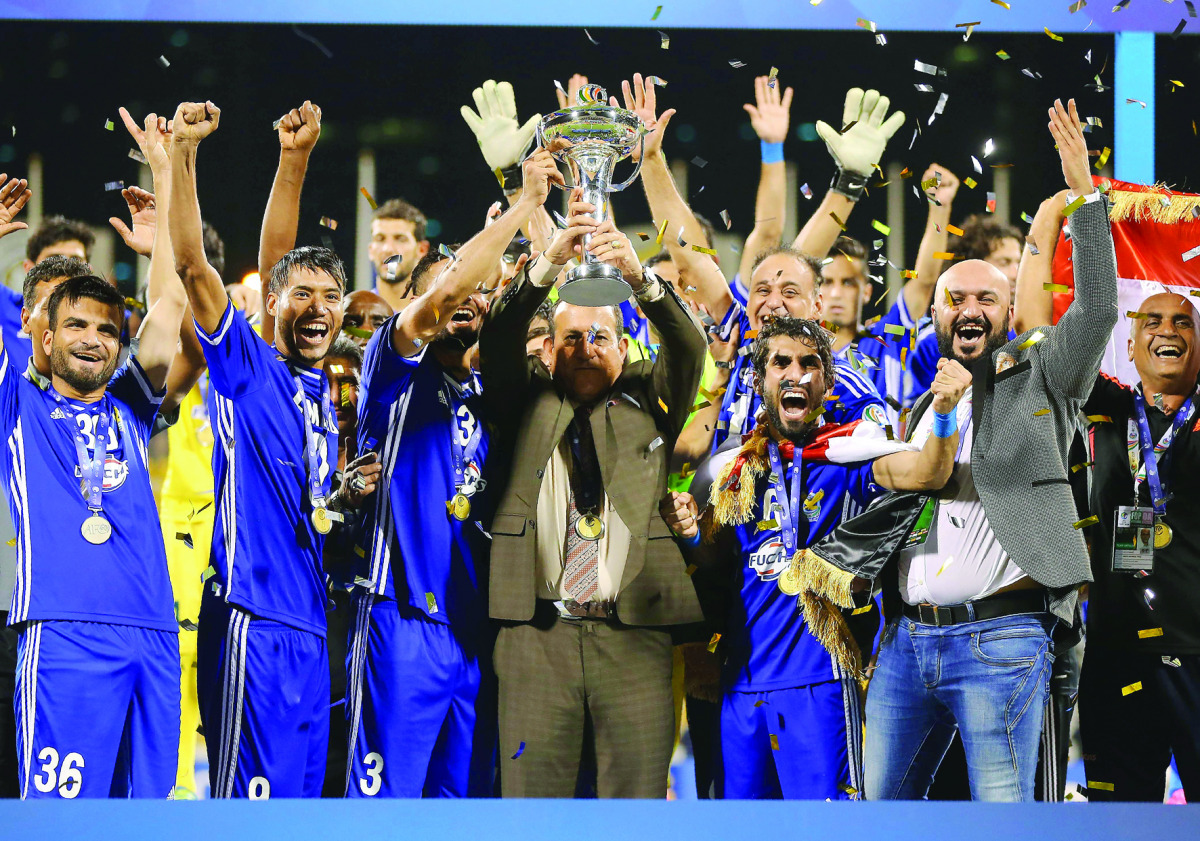 Iraq's Air Force Club coach Basim Qasim Hamdan Al Suwaid (centre) raises the trophy as he celebrates on the podium with his team after beating India's Bengaluru FC to win the AFC Asian Cup football final at the Qatar Sports Club Stadium in Doha, yesterday