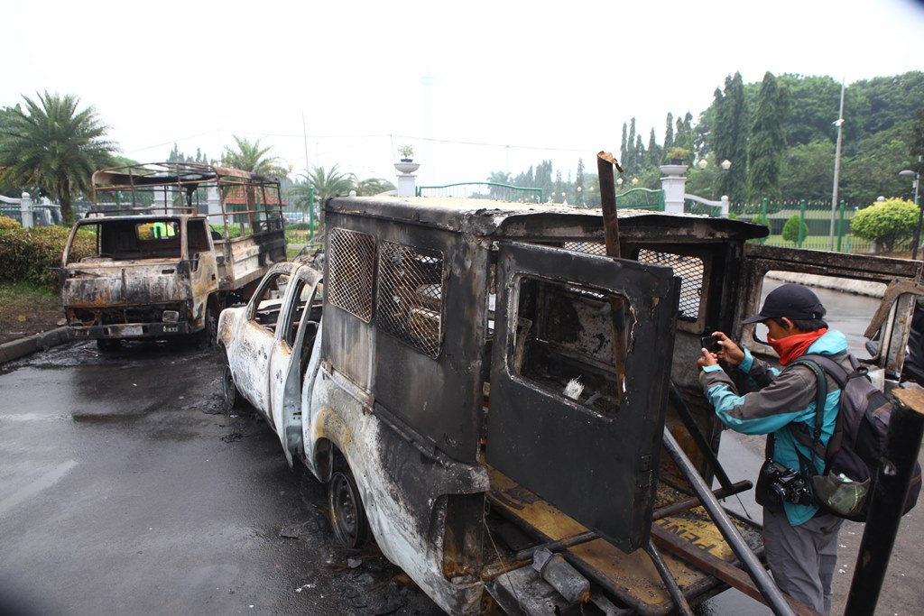 Wrecked cars are seen after the protests against Governor Basuki 