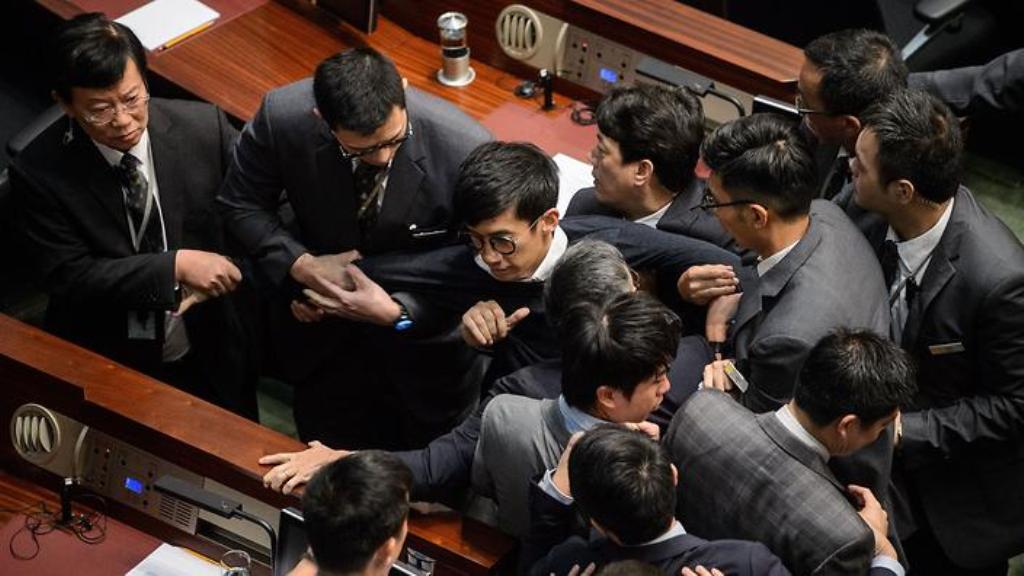 Newly elected lawmaker Baggio Leung is restrained after attempting to read out his Legislative Council oath at Legco in Hong Kong on November 2, 2016. (AFP)