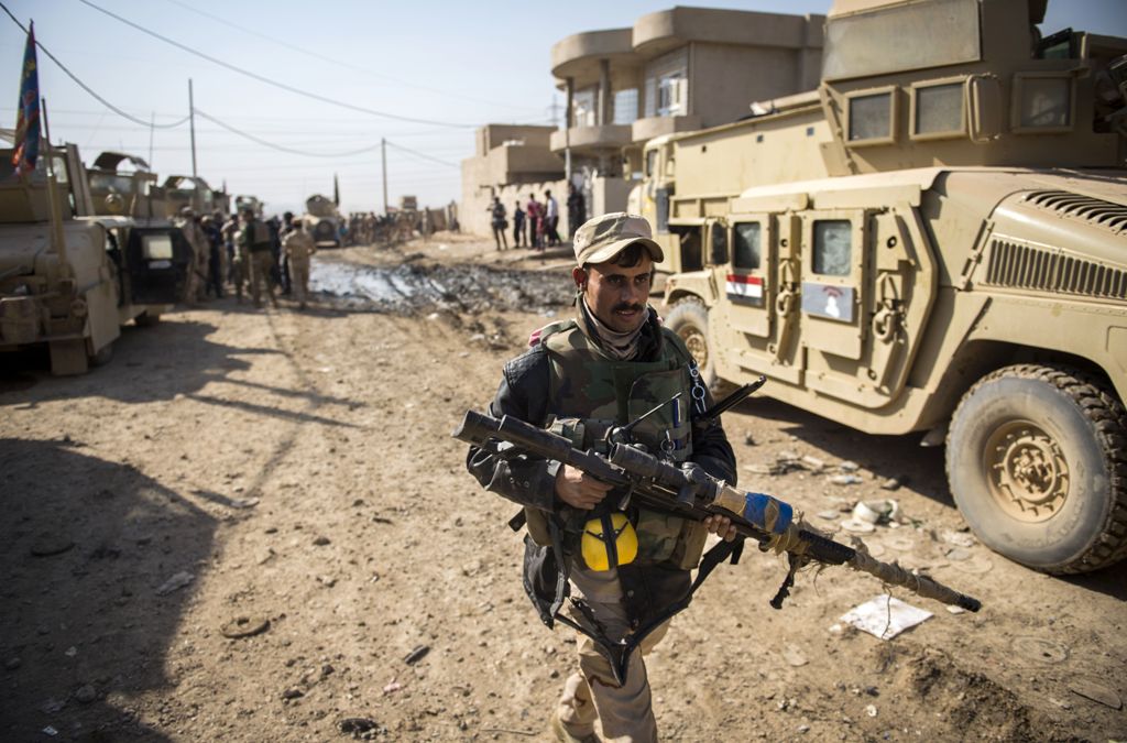 An Iraqi army sniper from the 9th armoured division walks to take his position in the area of Ali Rash, adjacent to the eastern Al-Intissar neighbourhood of Mosul, on November 6, 2016, during a military operation to retake the main hub city from the Islam