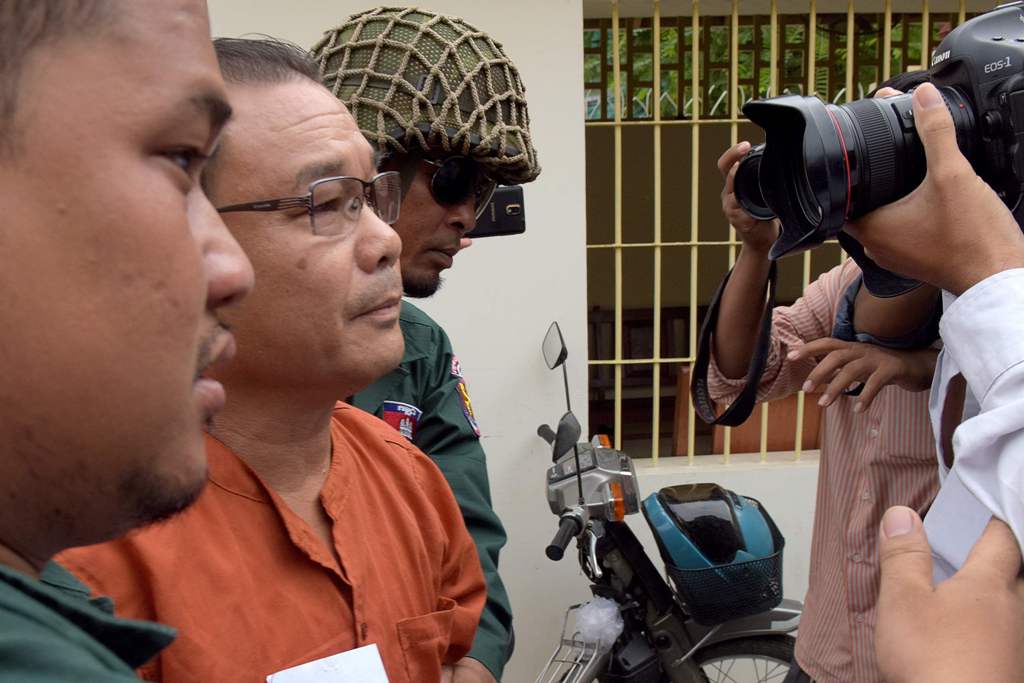 This photo taken on June 8, 2016 shows senator Hong Sok Hour (2nd L) from the Cambodia National Rescue Party (CNRP) being escorted by police at the Supreme Court in Phnom Penh. AFP / TANG CHHIN SOTHY