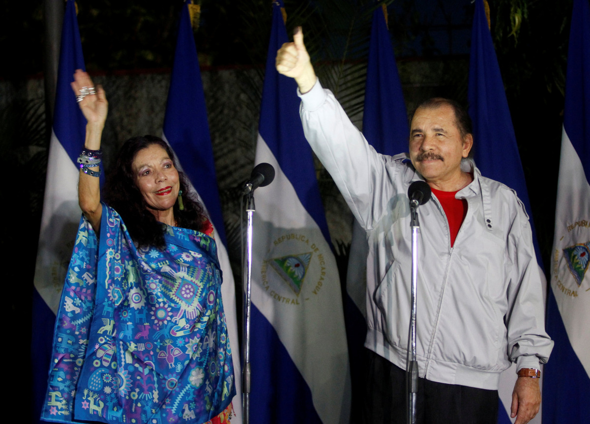 Daniel Ortega, Nicaragua's current president and presidential candidate from the ruling Sandinista National Liberation Front, shows his ink stained thumb to the media beside his wife Rosario Murillo after they casting their vote at a polling station durin