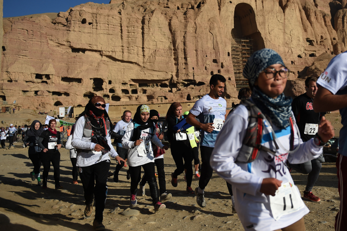 Afghan and international marathon runners take part in a marathon on a course that took them past the destroyed Buddha statues in Bamiyan province on November 4, 2016. Female athletes wearing headscarves raced November 4 against a backdrop of russet-hued 