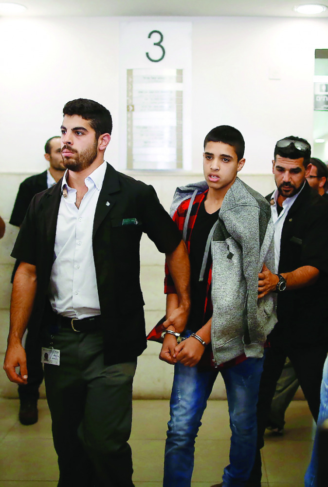 Ahmed Manasra (centre), a 14-year old Palestinian boy, leaves the District Court in Jerusalem after his sentencing. 