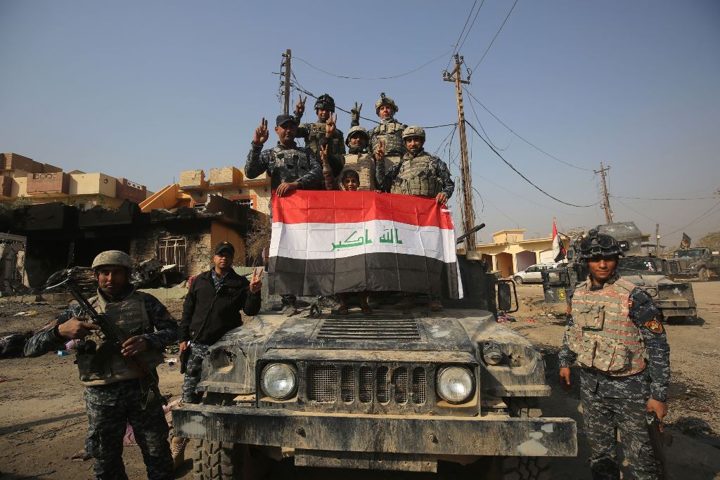 Iraqi forces flash the sign for victory in the Hamam al-Alil area, about 14 kilometres from the southern outskirts of Mosul, on November 7, 2016 after recapturing it from Islamic State (IS) group jihadists during the ongoing operation to retake Mosul. AFP
