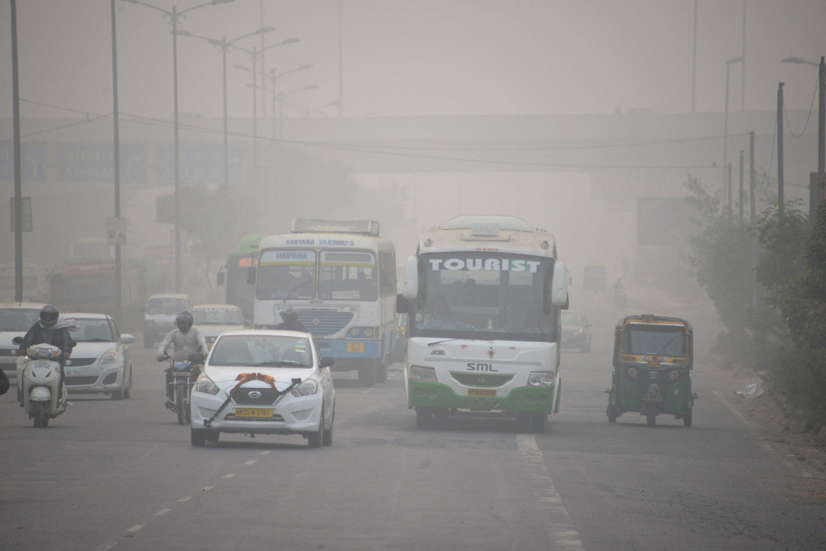 In this photograph taken on November 7, 2016, Indian commuters journey along a major road as heavy smog covers New Delhi. India's top court on November 8 gave the federal government two days to chalk out a plan to tackle alarming levels of smog in Delhi, 