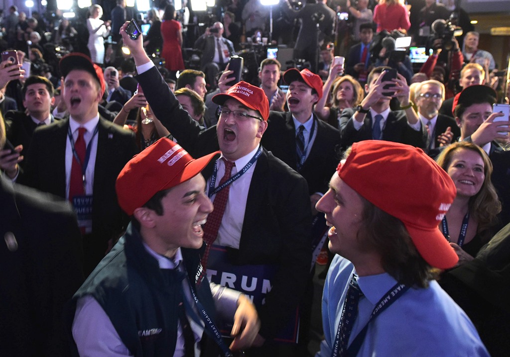 Supporters of Republican presidential nominee Donald Trump react to early poll results during election night at the New York Hilton Midtown in New York on November 8, 2016. / AFP / Mandel NGAN