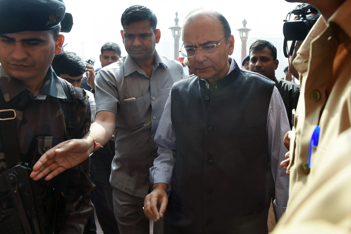Indian Finance Minister Arun Jaitley (R) arrives at the offices of the Ministry of Finance in New Delhi on November 9, 2016. Cash machines ran dry and stocks tumbled in India after Prime Minister Narendra Modi ordered the withdrawal of 500 and 1,000 rupee