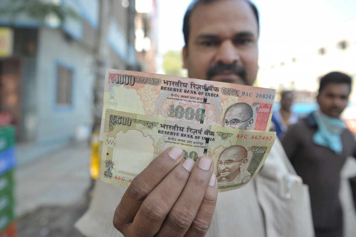 An Indian man display the currency of 500 and 1,000 rupees (15 USD) in Hyderabad on November 9, 2016. Indian Prime Minister Narendra Modi announced late November 8 that 500 and 1,000 rupee notes will be withdrawn from financial circulation from midnight, 
