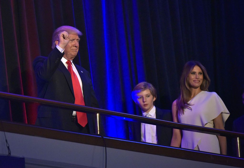 Republican presidential elect Donald Trump (L) waves to the crowd with his son Baron (C) and wife Melania (R) during election night at the New York Hilton Midtown in New York on November 9, 2016. / AFP.