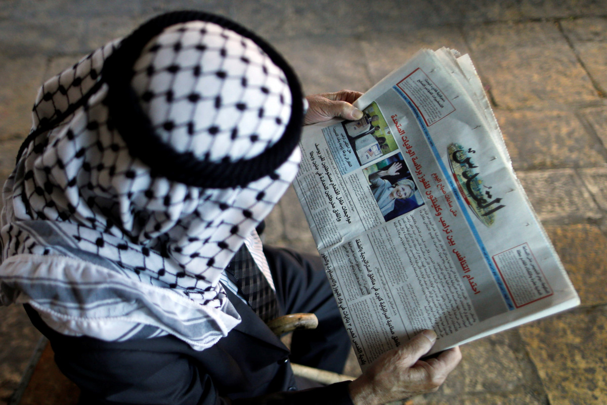 A Palestinian man reads the Al-Quds newspaper depicting images newly elected U.S. President Donald Trump and Democratic presidential nominee Hillary Clinton in Jerusalem's Old City November 9, 2016. REUTERS/Ammar Awad
