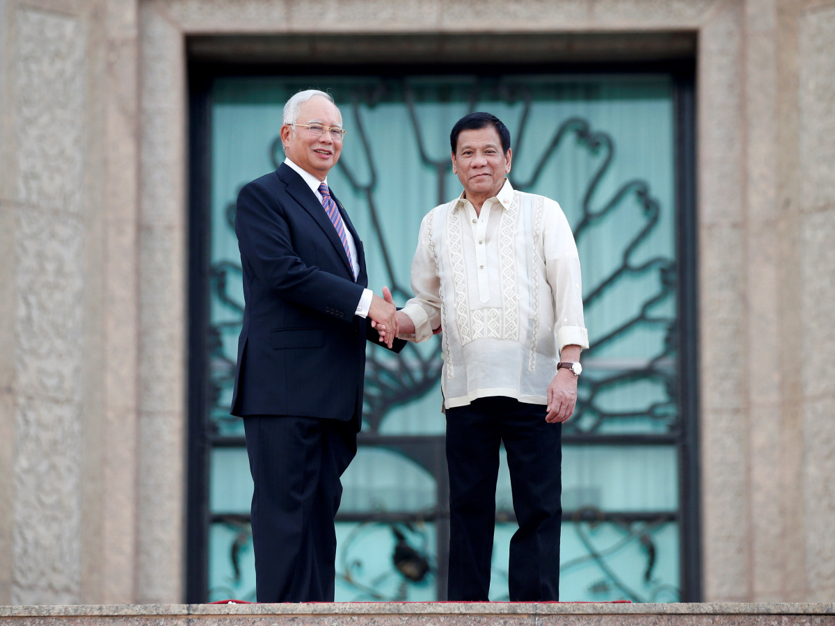 Philippines President Rodrigo Duterte and Malaysia's Prime Minister Najib Razak shake hands after a welcome ceremony in Putrajaya, Malaysia November 10, 2016. REUTERS/Edgar Su