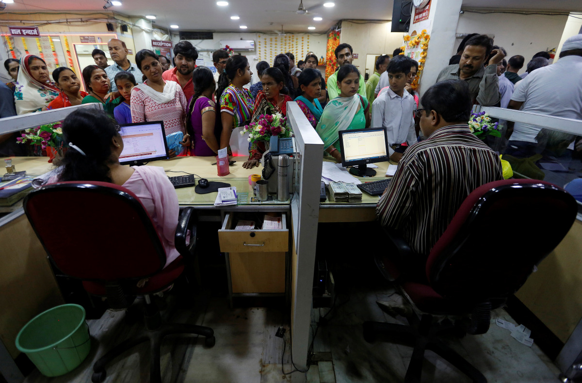 People stand in a queue to deposit 500 and 1000 Indian rupee banknotes inside a bank in the northern city of Kanpur, India, November 10, 2016. REUTERS/Adnan Abidi