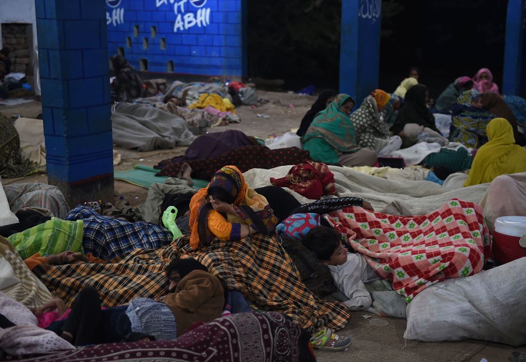Pakistani devotees take shelter after a suicide bomb attack near a shrine of Sufi saint Shah Noorani, some 750 kilometres (460 miles) south of Quetta, on November 13, 2016. AFP / ASIF HASSAN
