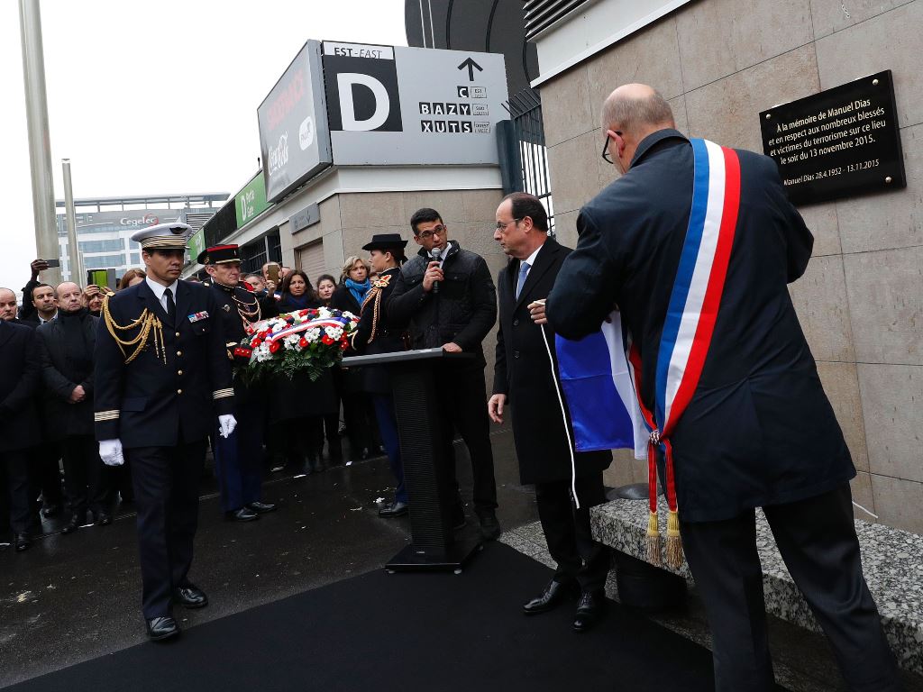 French President Francois Hollande (2L) and Saint-Denis Mayor Didier Paillard (R) unveil a commemorative plaque outside the Stade de France stadium, in Saint-Denis, north of Paris, on November 13, 2016, during a ceremony to mark the first anniversary of t