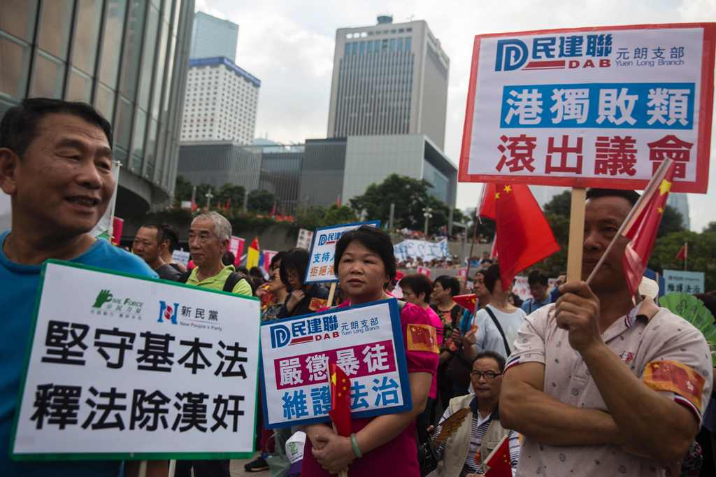 Pro-Beijing demonstrators hold placards outside the Hong Kong Legislative Council on November 13, 2016.  AFP / ISAAC LAWRENCE