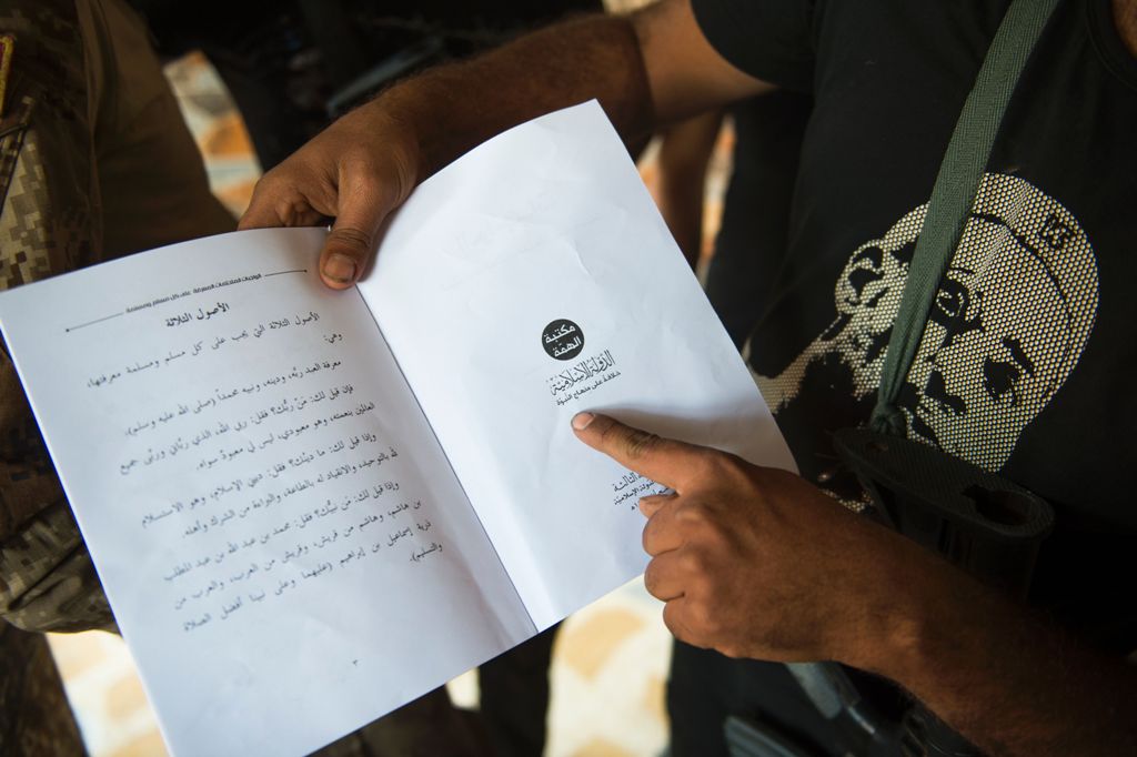 An Iraqi army soldier shows a schoolbook printed out by the Islamic State (IS) group and found in a house in the Samah area of Mosul, on November 12, 2016. AFP / Odd ANDERSEN