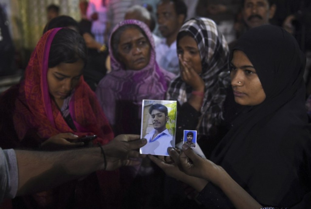 DEADLY BOMBING. Pakistani women show photos of missing relatives outside a hospital in Karachi on November 12, 2016, following a suicide bombing at a Sufi shrine. Photo by Rizwan Tabassum/AFP.