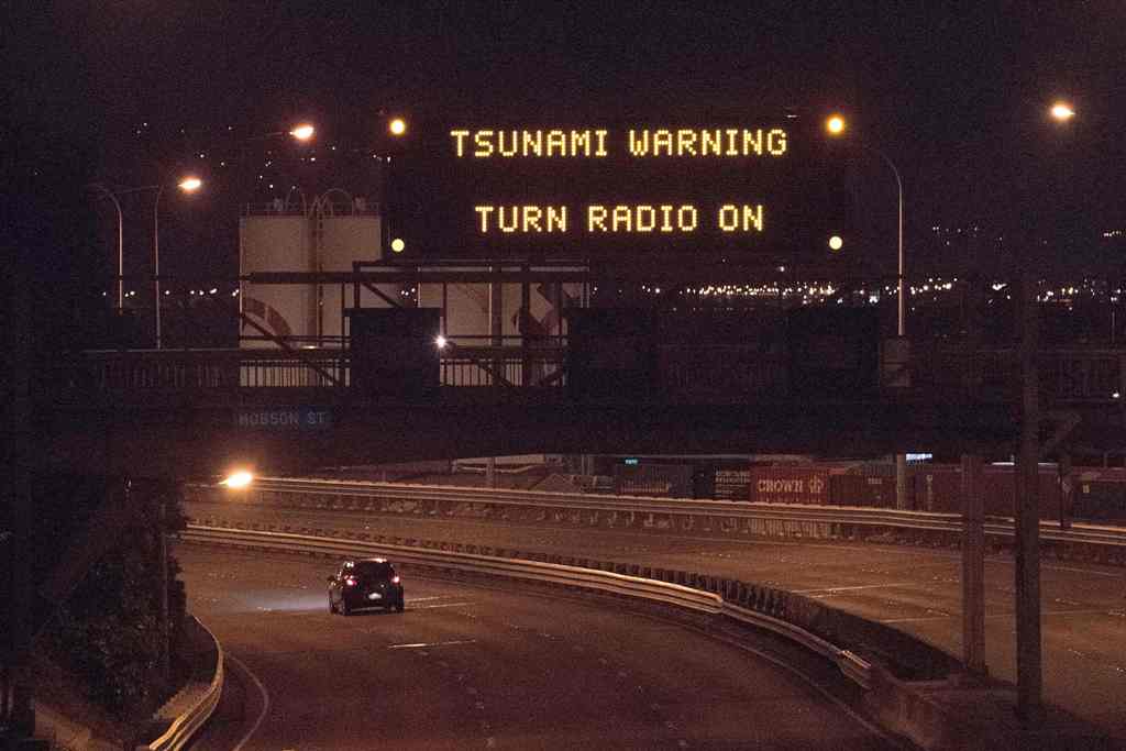 A tsunami warning alert is seen on a notice board above State Highway 1 in Wellington early on November 14, 2016 following an earthquake centred some 90 kilometres (57 miles) north of New Zealand's South Island city of Christchurch. A powerful 7.8 magnitu