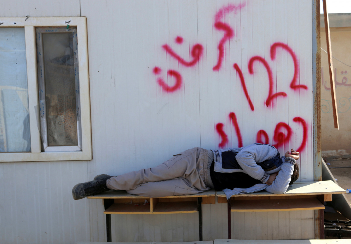 A displaced man sleeps on the table at a school used as a shelter in Bawiza, north of Mosul, Iraq November 13, 2016. REUTERS/Ari Jalal