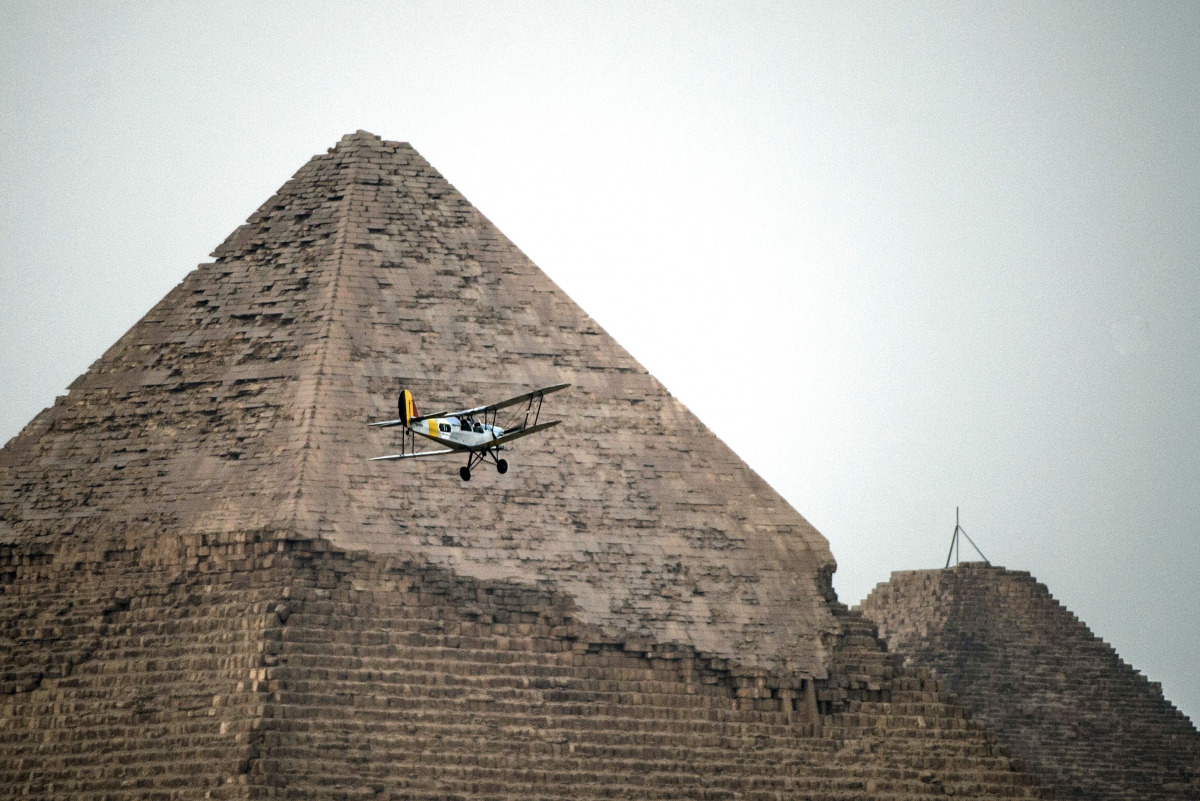 Belgian pilots Alexandra Maingard and her husband Cedric Collette fly their vintage Stampe OO-GWB biplane by one of the Pyramids of Giza, on the southern outskirts of the Egyptian capital Cairo on November 13, 2016 during the Vintage Air Rally (VAR). A do