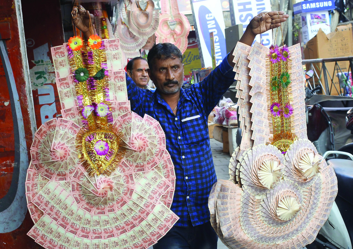 A man sells garlands made of Indian currency notes at a market in Jammu, India, November 13, 2016. REUTERS/Mukesh Gupta