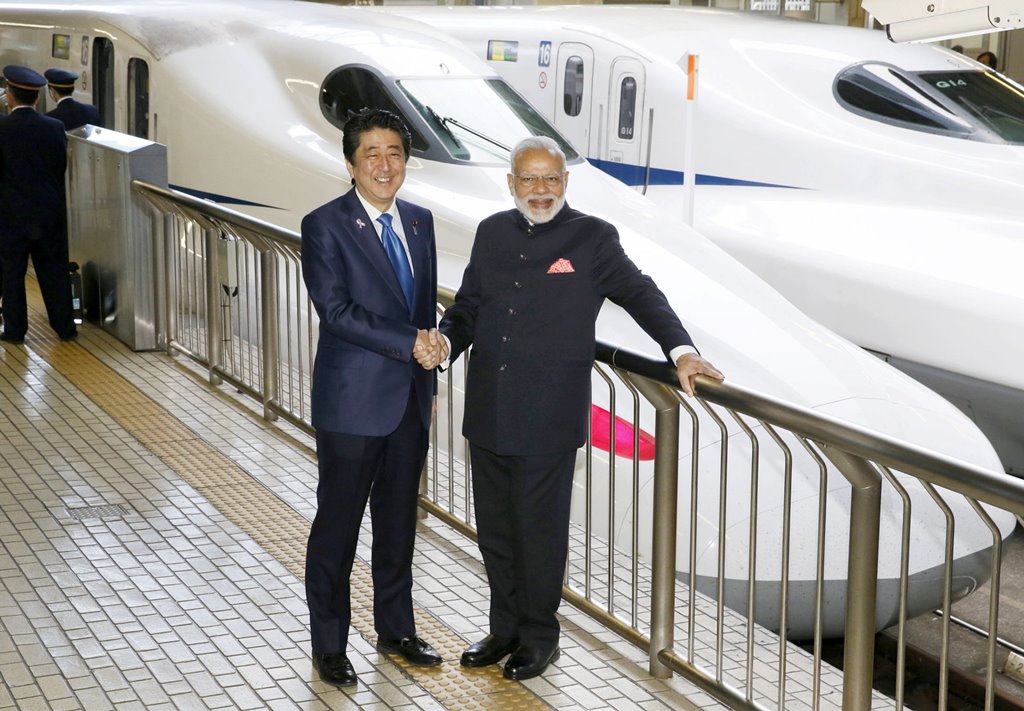 Indian Prime Minister Narendra Modi (R) and Japan's Prime Minister Shinzo Abe pose in front of a Shinkansen bullet train before heading for Hyogo prefecture at Tokyo Station, Japan November 12, 2016, in this photo taken by Kyodo. Kyodo/via REUTERS 