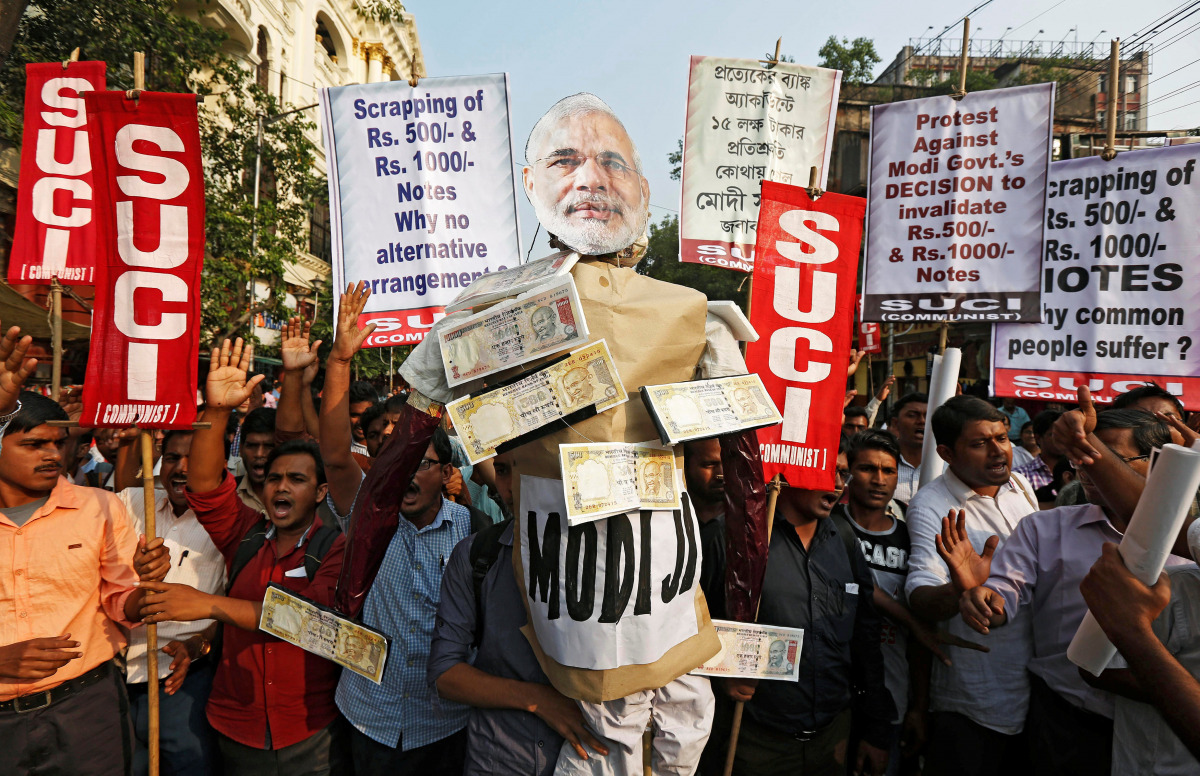 Activists of Socialist Unity Centre of India (SUCI) shout slogans as they carry an effigy of Prime Minister Narendra Modi during a protest against the government's decision to withdraw 500 and 1000 Indian rupee banknotes from circulation, according to a m